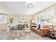 Comfortable living room with modern decor, a brown leather sofa, and natural light from the window at 6953 Elati Way, Denver, CO 80221