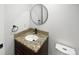 Modern bathroom featuring granite countertop, updated fixtures and a round mirror at 5480 W 74Th Ave, Arvada, CO 80003