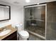 Bathroom featuring stone tiled shower with glass door, tiled floors and granite vanity top at 5480 W 74Th Ave, Arvada, CO 80003