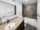Modern bathroom features granite countertop, dark cabinets, and beautiful stone shower and tub at 5480 W 74Th Ave, Arvada, CO 80003