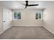 Cozy bedroom featuring carpet floors, two large windows, and a ceiling fan at 5480 W 74Th Ave, Arvada, CO 80003