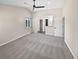 Open living room with a window, a ceiling fan, carpet, and an entry to the bathroom at 5480 W 74Th Ave, Arvada, CO 80003