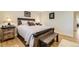 Comfortable bedroom with a stylish bed, wooden bench, and hardwood floors with white accents at 904 Fieldstone Pl, Highlands Ranch, CO 80126
