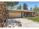 Spacious driveway leading to an attached garage, bordered by lush greenery and a well-maintained lawn at 904 Fieldstone Pl, Highlands Ranch, CO 80126