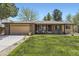 Charming brick home with a manicured lawn, inviting chairs on the front porch, and an attached two-car garage at 904 Fieldstone Pl, Highlands Ranch, CO 80126