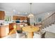 Open kitchen and dining area feature modern lighting, wood floors, and updated appliances at 3087 Deer Creek Trl, Highlands Ranch, CO 80129