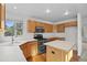 Charming kitchen featuring wood cabinets, a kitchen island, stainless steel appliances, and hardwood floors at 3087 Deer Creek Trl, Highlands Ranch, CO 80129
