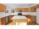 Charming kitchen featuring wood cabinets, a kitchen island, stainless steel appliances, and hardwood floors at 3087 Deer Creek Trl, Highlands Ranch, CO 80129