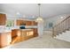 Open concept kitchen with wood cabinets, stainless appliances and hardwood floors with a decorative light fixture at 3087 Deer Creek Trl, Highlands Ranch, CO 80129