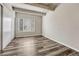 A vacant bedroom with wood floors, exposed beams, a large window, and neutral decor, ready for personalization at 2525 S Dayton Way # 2209, Denver, CO 80231