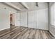 A bedroom with wood floors and neutral decor featuring a large closet, bathed in natural light, offers a blank canvas at 2525 S Dayton Way # 2209, Denver, CO 80231