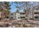 Two-story condo building with wood facade and private balconies surrounded by mature trees and landscaping at 2525 S Dayton Way # 2209, Denver, CO 80231
