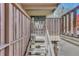 View of home's staircase and gated entrance, featuring a wood-toned railing, steps, and address marker at 2525 S Dayton Way # 2209, Denver, CO 80231