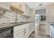Well-lit kitchen featuring stainless steel appliances, black granite counters, and a neutral colored tile backsplash at 2525 S Dayton Way # 2209, Denver, CO 80231