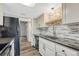 Well-lit kitchen featuring stainless steel appliances, black granite counters, and a neutral colored tile backsplash at 2525 S Dayton Way # 2209, Denver, CO 80231