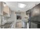 Well-lit kitchen featuring stainless steel appliances, black granite counters, and a neutral colored tile backsplash at 2525 S Dayton Way # 2209, Denver, CO 80231