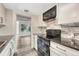 Well-lit kitchen featuring stainless steel appliances, black granite counters, and a neutral colored tile backsplash at 2525 S Dayton Way # 2209, Denver, CO 80231