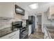 Well-lit kitchen featuring stainless steel appliances, black granite counters, and a neutral colored tile backsplash at 2525 S Dayton Way # 2209, Denver, CO 80231