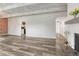 Bright living room with wood-look flooring and a brick accent wall, leading to the kitchen at 2525 S Dayton Way # 2209, Denver, CO 80231