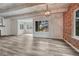 Bright living room featuring hardwood floors, white wood paneled walls, exposed brick, and modern light fixture at 2525 S Dayton Way # 2209, Denver, CO 80231
