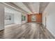 Open living area featuring exposed ceiling beams, gray flooring, and a red brick accent wall at 2525 S Dayton Way # 2209, Denver, CO 80231