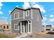 Charming gray two-story home with a welcoming front porch and neatly landscaped gravel yard at 3004 Oxley St, Strasburg, CO 80136