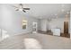 Spacious living room with carpet, slider to the outdoors, fan and easy access to the modern kitchen at 3004 Oxley St, Strasburg, CO 80136
