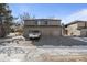 Front view of tan multi-unit building with attached garages and parking at 10212 W 80Th Dr # C, Arvada, CO 80005