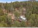 Scenic aerial view of a mountain home nestled among lush, mature trees and landscapes at 26349 Pleasant Park Rd, Conifer, CO 80433