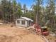 Exterior of a cozy mountain home with a wooden walkway to a deck surrounded by trees at 26349 Pleasant Park Rd, Conifer, CO 80433