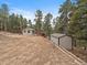 Exterior view of home and detached shed surrounded by beautiful trees at 26349 Pleasant Park Rd, Conifer, CO 80433