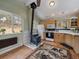 Classic kitchen design featuring a charming wood-burning stove and light wood cabinets and modern appliances at 26349 Pleasant Park Rd, Conifer, CO 80433