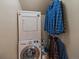 Functional laundry area with stacked washer and dryer, plus hanging rack at 26349 Pleasant Park Rd, Conifer, CO 80433
