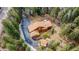 Aerial view of the house surrounded by dense trees and a long private driveway at 9590 S Warhawk Rd, Conifer, CO 80433