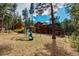 Exterior view of the home from the spacious backyard with a playground set at 9590 S Warhawk Rd, Conifer, CO 80433