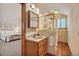 Bright bathroom with a walk-in shower, single vanity, and a clear view to the bedroom at 9590 S Warhawk Rd, Conifer, CO 80433