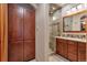 Bathroom with double vanity, wood cabinets, and a glass-enclosed shower at 9590 S Warhawk Rd, Conifer, CO 80433