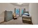 Cozy bedroom featuring neutral colors, a comfortable bed, and a rocking chair at 9590 S Warhawk Rd, Conifer, CO 80433