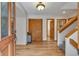Inviting entryway featuring hardwood floors, a wood door, and a staircase leading to the upper level at 9590 S Warhawk Rd, Conifer, CO 80433