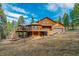 Exterior view of the home with a wooden deck and attached garage at 9590 S Warhawk Rd, Conifer, CO 80433
