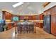 Gourmet kitchen featuring a central island with seating, wood cabinetry, and modern appliances at 9590 S Warhawk Rd, Conifer, CO 80433