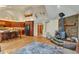 Open living space featuring wood floors, a stone fireplace, and a kitchen with a breakfast bar at 9590 S Warhawk Rd, Conifer, CO 80433