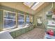 Bright sunroom with multiple windows, tile floors, storage cabinets and a skylight at 9590 S Warhawk Rd, Conifer, CO 80433