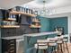 Finished basement features a wet bar with stone countertops, shelving, and decorative lighting at 17880 Weymouth Ave, Parker, CO 80134
