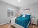 Comfortable bedroom featuring hardwood floors, a white bed frame, blue bedding, and a bright window at 17880 Weymouth Ave, Parker, CO 80134
