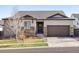 Charming single-Gathering home with a two-car garage, brown trim, stone accents, and a welcoming front door with a wreath at 17880 Weymouth Ave, Parker, CO 80134