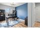 Bright home office space with hardwood floors, large window, dark wood desk, and ample storage at 17880 Weymouth Ave, Parker, CO 80134