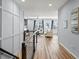 Bright living room with hardwood floors, light walls, white couches, and view into additional living space at 17880 Weymouth Ave, Parker, CO 80134