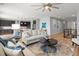 Open-concept living room with hardwood floors, white couches, views of the kitchen, stainless appliances, and breakfast bar at 17880 Weymouth Ave, Parker, CO 80134