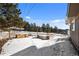 Snowy backyard with wood planters and bench at 23465 Weisshorn Dr, Indian Hills, CO 80454